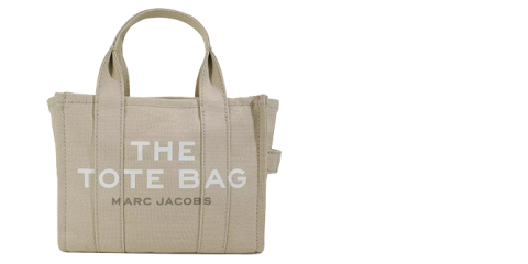 Beigefarbene Tragetasche mit Griffen und den Worten „THE TOTE BAG“ und „MARC JACOBS“ in Weiß auf der Vorderseite aufgedruckt. Die Tasche ist schlicht und strukturiert, mit sichtbaren Nähten und einem seitlichen Riemendetail.