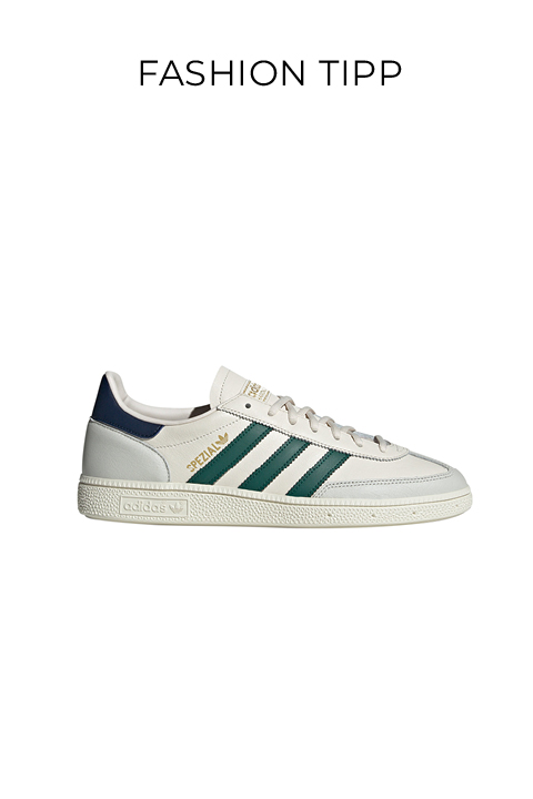 Ein weißer Adidas-Sneaker mit grünen Streifen, beigen Schnürsenkeln und goldenem Adidas-Branding, dargestellt auf einem schlichten weißen Hintergrund mit dem Text "FASHION TIPP" darüber.
