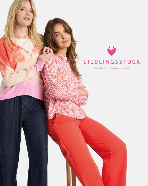 Eine Frau mit einer rosa-roten Strickmütze, einem hellrosa Pullover, einer beigen Pufferweste und einem Jeanshemd steht vor einer Holzwand. Sie sieht nachdenklich aus und hat den Kopf auf ihre Hand gestützt. Der Text lautet "LIEBLINGSSTÜCK.