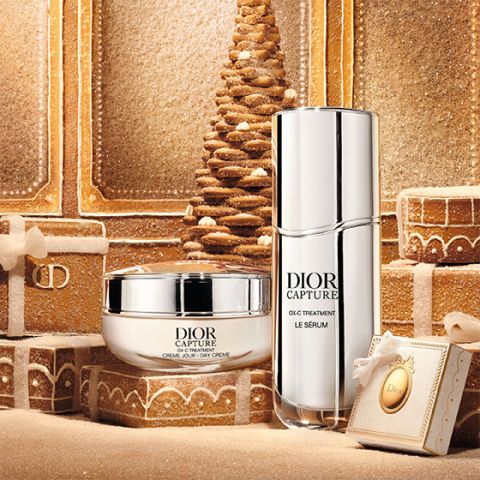 Eine silberne Tube mit der Aufschrift „Dior Capture“, die aufrecht auf einem weißen Hintergrund steht und deren Schatten nach rechts fällt.