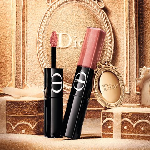 Ein roter flüssiger Lippenstift von Dior, dessen Applikator herausgezogen ist und dessen silberne Kappe daneben liegt, alles vor einem weißen Hintergrund.
