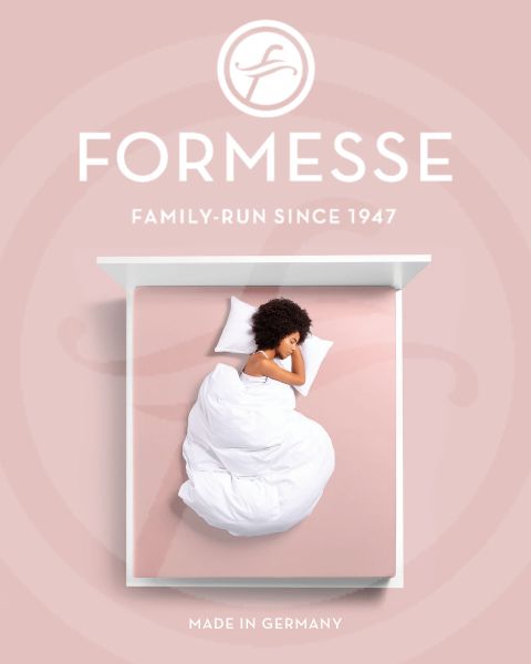Eine Frau mit blondem Haar schläft seitlich auf einem hellblauen Bett. Ihr Kopf ruht auf einem weißen Kissen. Am unteren Bildrand sind der Schriftzug „Formesse“ und ein Logo zu sehen.