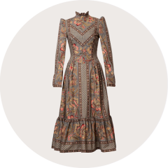 Ein ärmelloses, rosarotes Dirndlkleid mit tailliertem Mieder, Knopfleiste und passender Schärpe, die in der Taille gebunden wird, auf weißem Hintergrund.