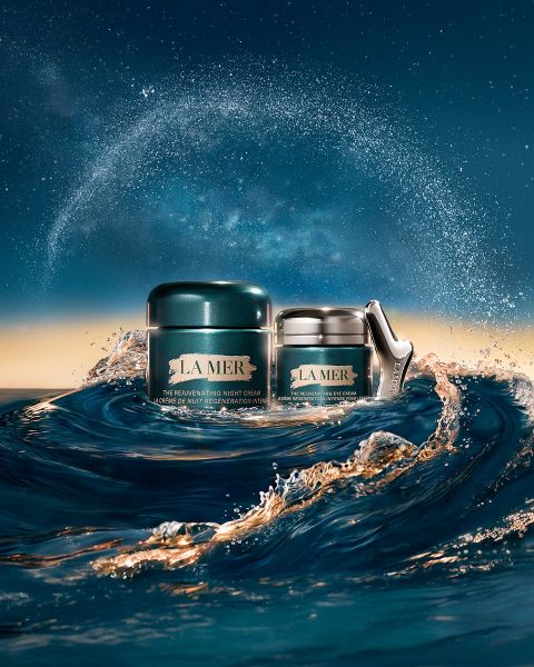 Ein Glas Feuchtigkeitscreme von La Mer schwimmt auf schimmerndem blauem Wasser. Text lautet: „Regeneration aus dem Meer. Sichtbare Verwandlung. Tag für Tag.“ und „LA MER #LoveLaMer.