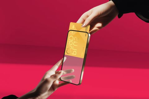 Zwei Hände tauschen eine digitale Karte durch einen transparenten Smartphone-Bildschirm vor einem leuchtend rosa Hintergrund aus. Die digitale Karte ist goldfarben mit abstrakten Designs und Text.