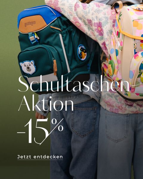 Zwei Kinder mit bunten Rucksäcken stehen nebeneinander. Der grüne Rucksack ist mit einem Eisbärenmotiv versehen, der helle mit Punkten. Auf grünem Hintergrund steht „Schultaschen Aktion -15% Jetzt entdecken“.