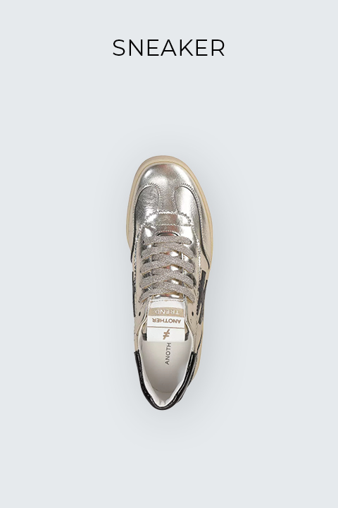 Draufsicht auf einen metallisch-silbernen Sneaker mit beigen Schnürsenkeln, weißer Sohle und einem schwarzen Sterndesign an der Seite. Der Hintergrund ist hellgrau, und über dem Schuh steht das Wort „SNEAKER“.