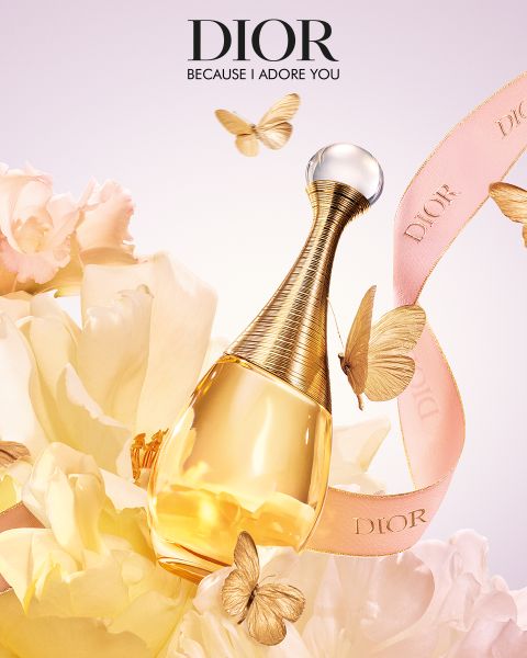 Ein luxuriöser Dior-Parfümflakon, umgeben von goldenen Schmetterlingen und zartgelben Blumen. Ein rosa Band mit der Aufschrift „Dior“ schlängelt sich durch die Szene. Oben steht der Text „Dior, weil ich dich verehre“.