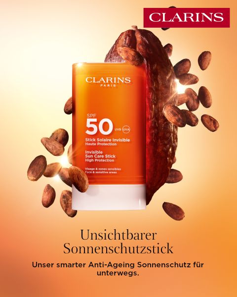 Ein Clarins Sonnenschutzstift mit Lichtschutzfaktor 50 ist mit Kakaobohnen auf einem orangefarbenen Hintergrund mit Farbverlauf abgebildet. Der Text hebt den hohen Schutz und die Anti-Aging-Vorteile der Sonnenpflege auf Deutsch hervor.