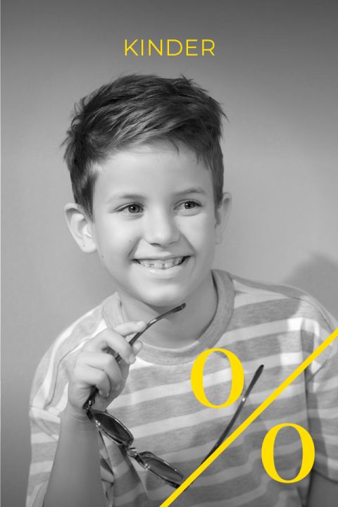 Schwarz-Weiß-Foto eines lächelnden Jungen in einem gestreiften Hemd mit Brille. Das Wort „KINDER“ und ein gelbes Prozentzeichen sind in gelber Schrift über das Bild gelegt.