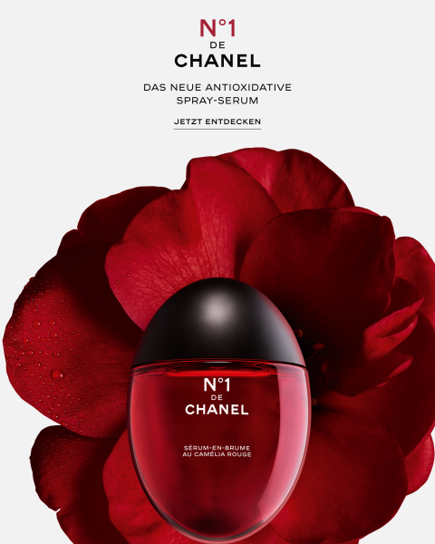 Vor einer großen roten Kamelienblüte auf weißem Hintergrund ist ein roter Flakon des Chanel N°1 Sprühserums abgebildet, das in deutscher Sprache als neues antioxidatives Sprühserum beschrieben wird.