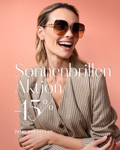 Eine lächelnde Frau mit großer Sonnenbrille und kariertem Blazer posiert vor einem pfirsichfarbenen Hintergrund. Der Text auf Deutsch lautet: „Sonnenbrillen Aktion -15 %. Jetzt entdecken.“.