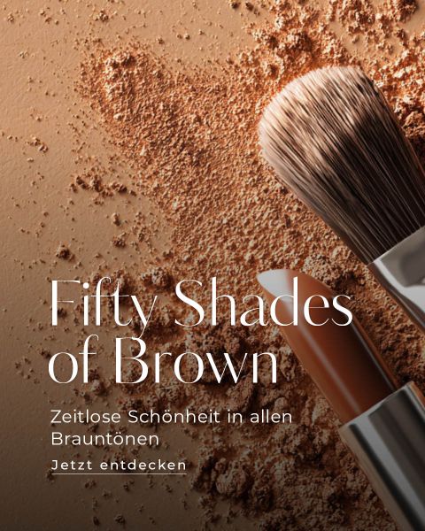 Ein Schminkpinsel, brauner Puder und ein brauner Lippenstift sind auf einer braunen Fläche angeordnet. Der Text lautet: "Fifty Shades of Brown. Zeitlose Schönheit in allen Brauntönen. Jetzt entdecken.