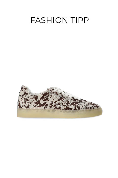 Ein Low-Top-Sneaker mit weißem Grund und braunem Sprenkelmuster, weißen Schnürsenkeln und einer durchsichtigen Gummisohle. Der Text "FASHION TIPP" steht über dem Schuh auf einem schlichten weißen Hintergrund.