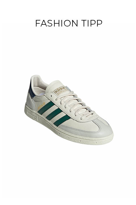 Ein weißer Adidas-Sneaker mit grünen Streifen, beigen Schnürsenkeln und goldenem Adidas-Branding, dargestellt auf einem schlichten weißen Hintergrund mit dem Text "FASHION TIPP" darüber.