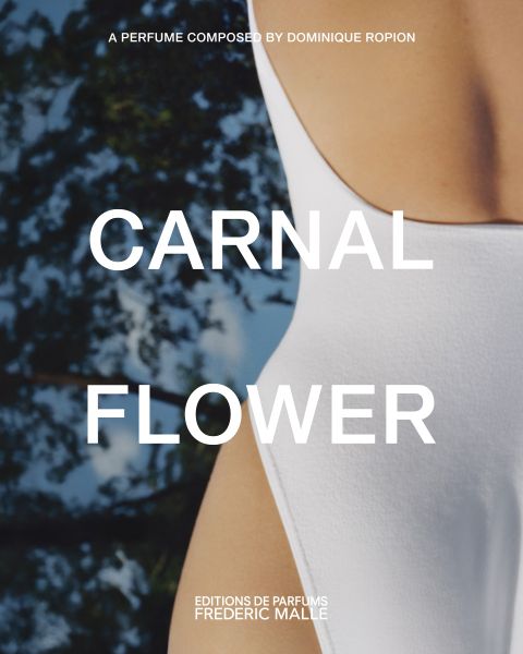 Nahaufnahme einer Person in einem weißen Badeanzug, mit unscharfen Bäumen im Hintergrund. Ein großer Text über dem Bild lautet "CARNAL FLOWER". Im weiteren Text werden Dominique Ropion und Editions de Parfums Frederic Malle erwähnt.