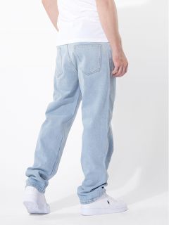 Eine Person, die hellblaue Jeans, ein weißes T-Shirt und weiße Turnschuhe trägt, steht vor einem schlichten weißen Hintergrund, von hinten und leicht zur Seite gedreht.
