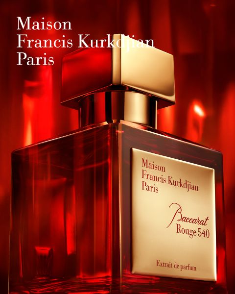 Ein rot-goldener Flakon des Parfums Baccarat Rouge 540 von Maison Francis Kurkdjian Paris mit einem warmen roten Hintergrund und eleganter Beleuchtung.