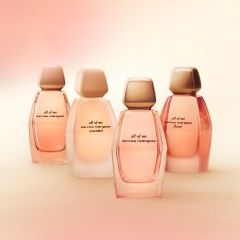 Vier Flakons des Parfüms „All of Me“ von Narciso Rodriguez in zarten Rosa- und Beigetönen, arrangiert vor einem hellen, sanft unscharfen Hintergrund.