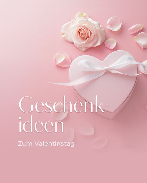 Herzförmige Geschenkbox mit weißem Band, rosa Rose und Blütenblättern auf rosa Hintergrund. Text: "Geschenkideen Zum Valentinstag" (Geschenkideen zum Valentinstag).