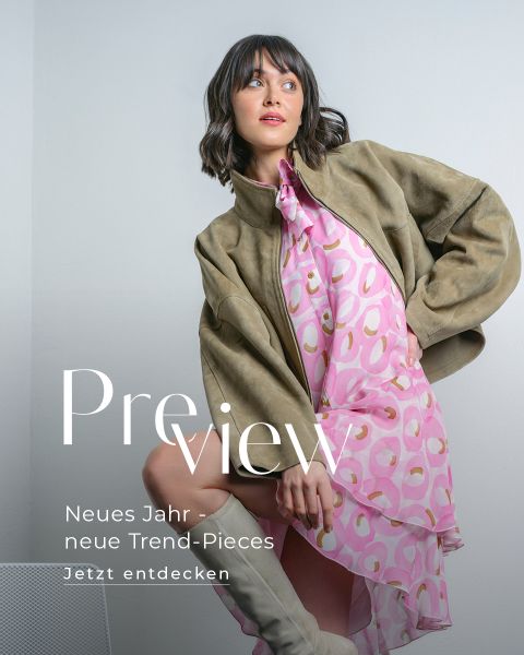 Frau in hellbrauner Jacke und rosa gemustertem Kleid posiert mit einem hochgezogenen Knie im Sitzen. Text: "Vorschau. Neues Jahr - neue Trend-Pieces. Jetzt entdecken".