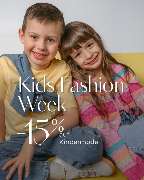Zwei lächelnde Kinder sitzen auf einer gelben Couch. Der Text lautet: "Kids Fashion Week -15% auf Kindermode.