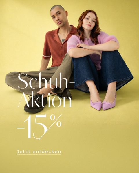 Ein Mann und eine Frau sitzen auf einem gelben Fußboden und präsentieren ihre Schuhe. Text: Schuh-Aktion -15%. Jetzt entdecken.