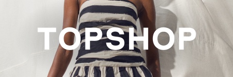 Eine Frau in einem trägerlosen gestreiften Oberteil und einer khakifarbenen Hose posiert vor einem weißen Hintergrund und hält eine Clutch. Das Wort "TOPSHOP" erscheint über dem Bild.