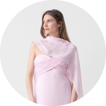 Frau in einem hellrosa, asymmetrischen Kleid mit einem drapierten Schal blickt vor einem schlichten, hellgrauen Hintergrund zur Seite.
