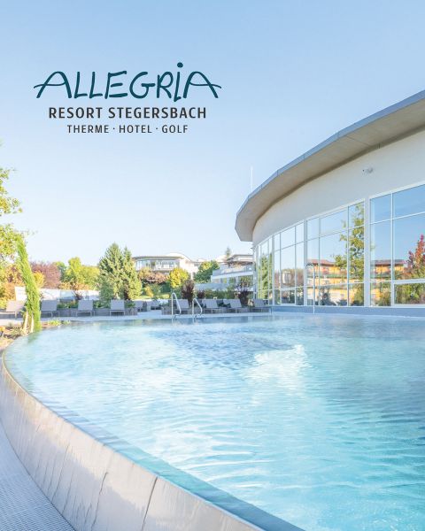Ein moderner, geschwungener Außenpool im Allegria Resort Stegersbach, mit klarem, blauem Wasser und umliegenden Grünflächen unter einem strahlenden Himmel.