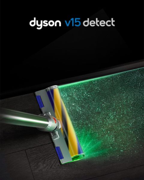 Der Dyson V15 Detect saugt einen dunklen Boden, wobei ein grüner Laserstrahl Staub und Schmutz sichtbar macht.