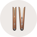 Zwei Haarglätter aus Bronze stehen nebeneinander aufrecht auf einem weißen Hintergrund, einer geschlossen und einer geöffnet, sodass ihr Design und ihre Bedienelemente zu sehen sind.