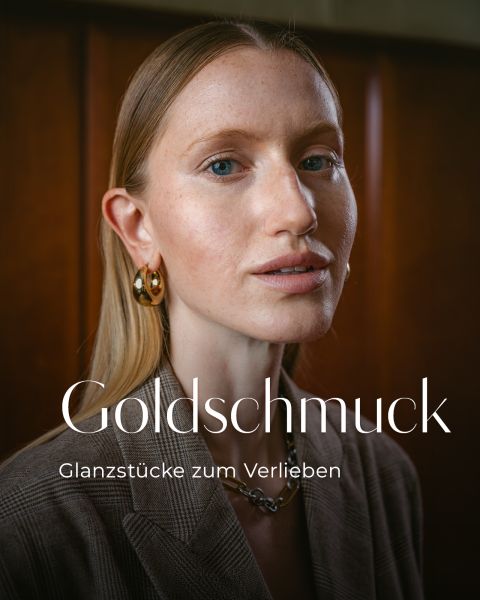 Eine Frau mit langen blonden Haaren trägt goldene Ohrringe und einen braunen Blazer. Der Text lautet: „Goldschmuck – Glanzstücke zum Verlieben.“.