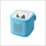 Ein blauer Toniebox-Audioplayer mit katzenartigen Ohren und einem pixeligen Katzengesicht auf der Lautsprecherseite, vor einem weißen Hintergrund.