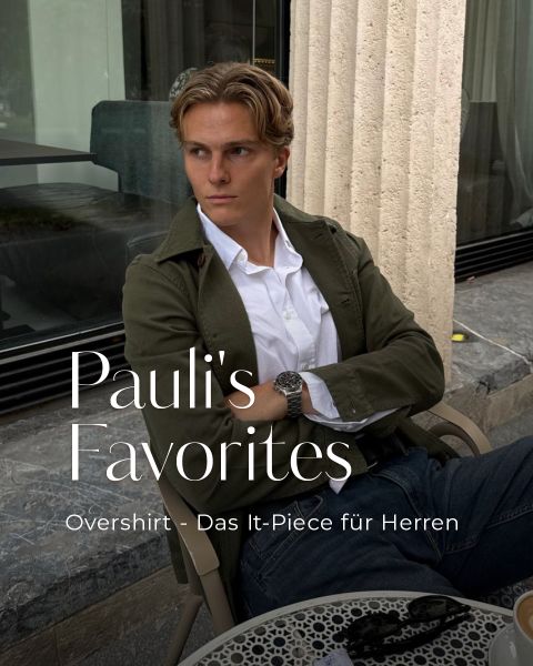 Ein Mann in einem olivfarbenen Overshirt sitzt an einem Tisch im Freien und blickt zur Seite. Text: „Pauli’s Favorites. Overshirt – Das It-Piece für Herren.“.