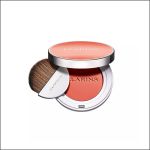 Runde, kompakte Rouge-Dose von Clarins in einem Korallenton, geöffnet, sodass das Puder und der geschwungene Pinsel zu sehen sind, vor weißem Hintergrund.