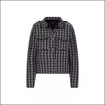Schwarz-weiß gemusterte Langarmjacke mit Kragen, Vordertaschen und Knopfdetails, abgebildet vor einem einfarbigen weißen Hintergrund.