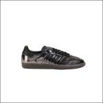 Ein schwarzer Adidas Samba-Sneaker mit glänzender Oberfläche und Gummisohle, im Profil vor einem schlichten weißen Hintergrund abgebildet.