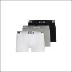 Drei Paar BOSS-Boxershorts in Weiß, Grau und Schwarz, die in einer Reihe mit den Markenlogos auf den Bundbändern präsentiert werden.