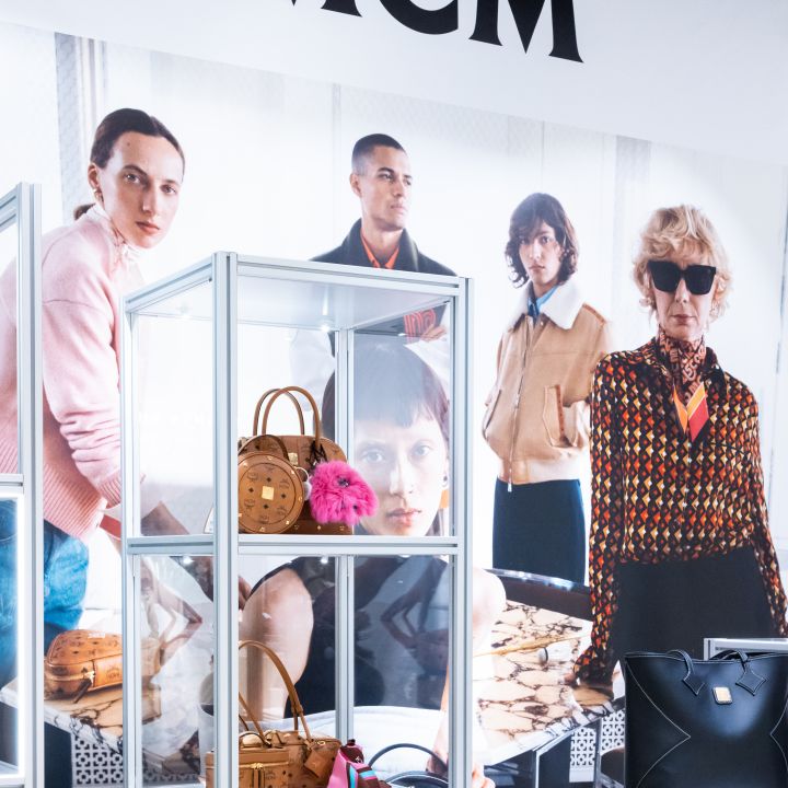 Display booth for MCM fashion brand with mannequins and glass showcases of handbags and accessories