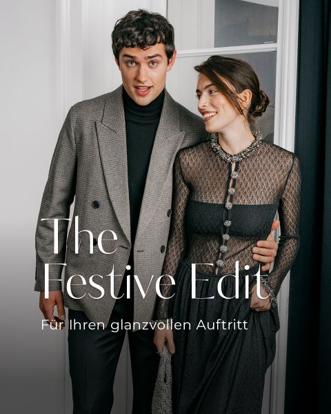 Ein Mann in Blazer und Rollkragenpullover steht neben einer Frau in einem schwarzen Kleid; darüber ist der Text „Festliche Looks für Ihren glanzvollen Auftritt“ eingeblendet.