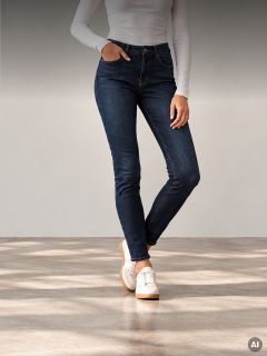 Eine Person, die ein weißes Langarmhemd, eine dunkelblaue Skinny-Jeans und weiße Sneaker trägt.