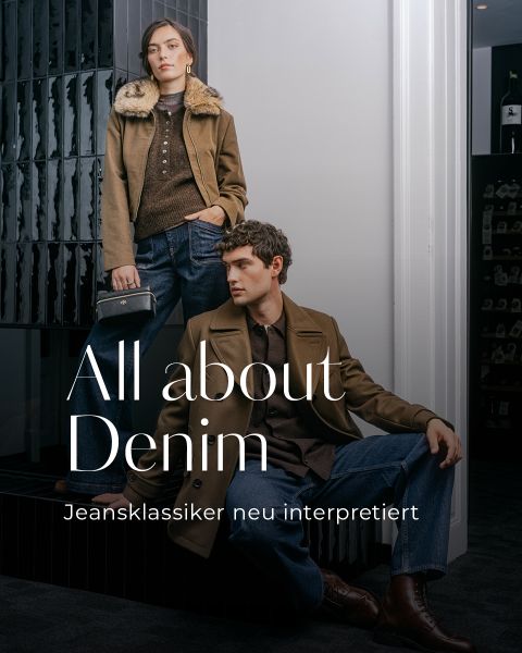 Eine Frau und ein Mann in braunen Jacken und Jeans posieren in einem Innenraum; der Text lautet: „Alles rund um Denim – Jeansklassiker neu interpretiert.“.