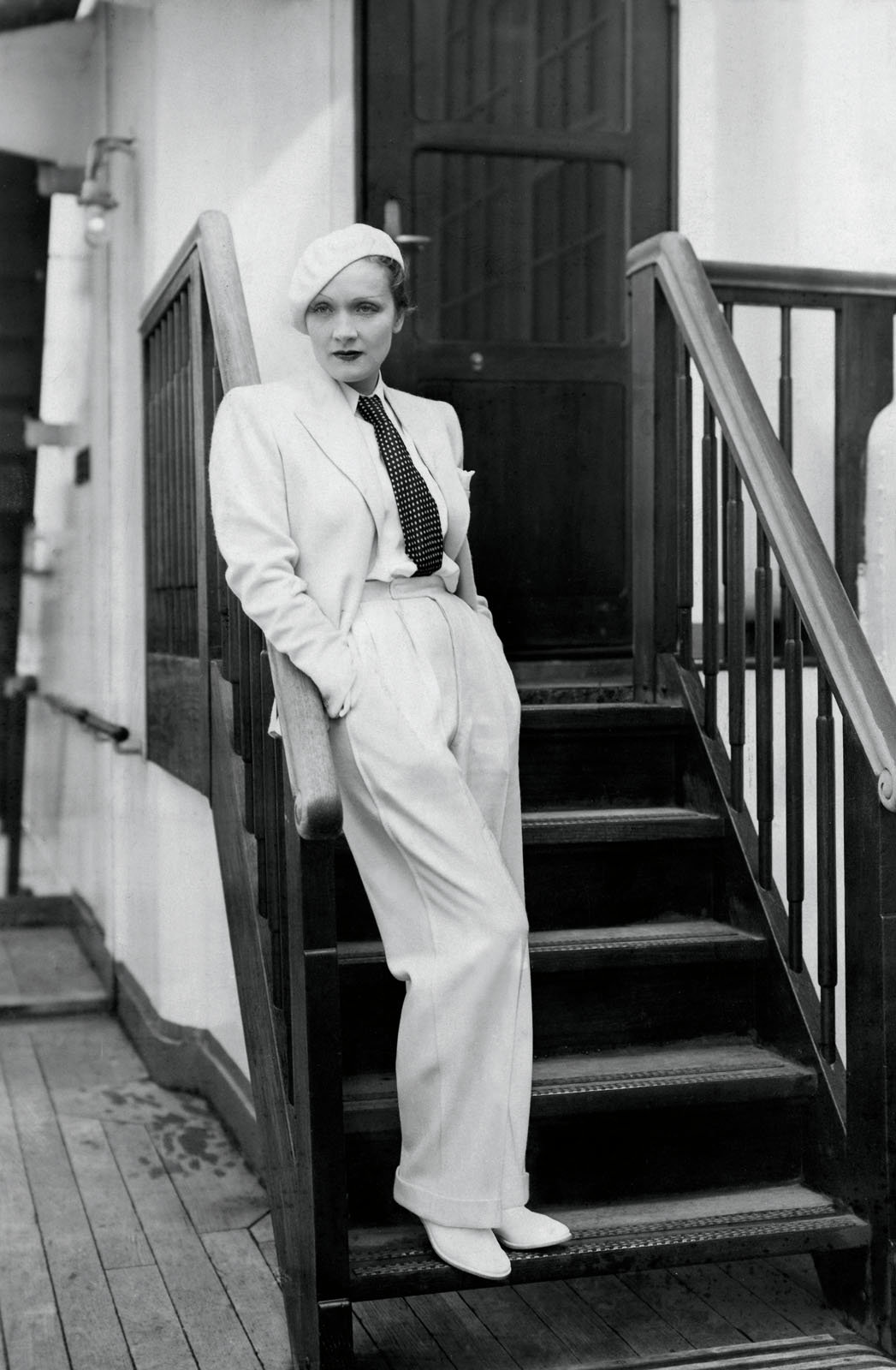 Marlene SKANDALÖS SEXY MARLENE DIETRICH IN HOCH SITZENDEN MÄNNERHOSEN, AUSSTAFFIERT MIT DEM ZIERRAT DER MACHT: SCHULTERPOLSTER UND SCHLIPS.